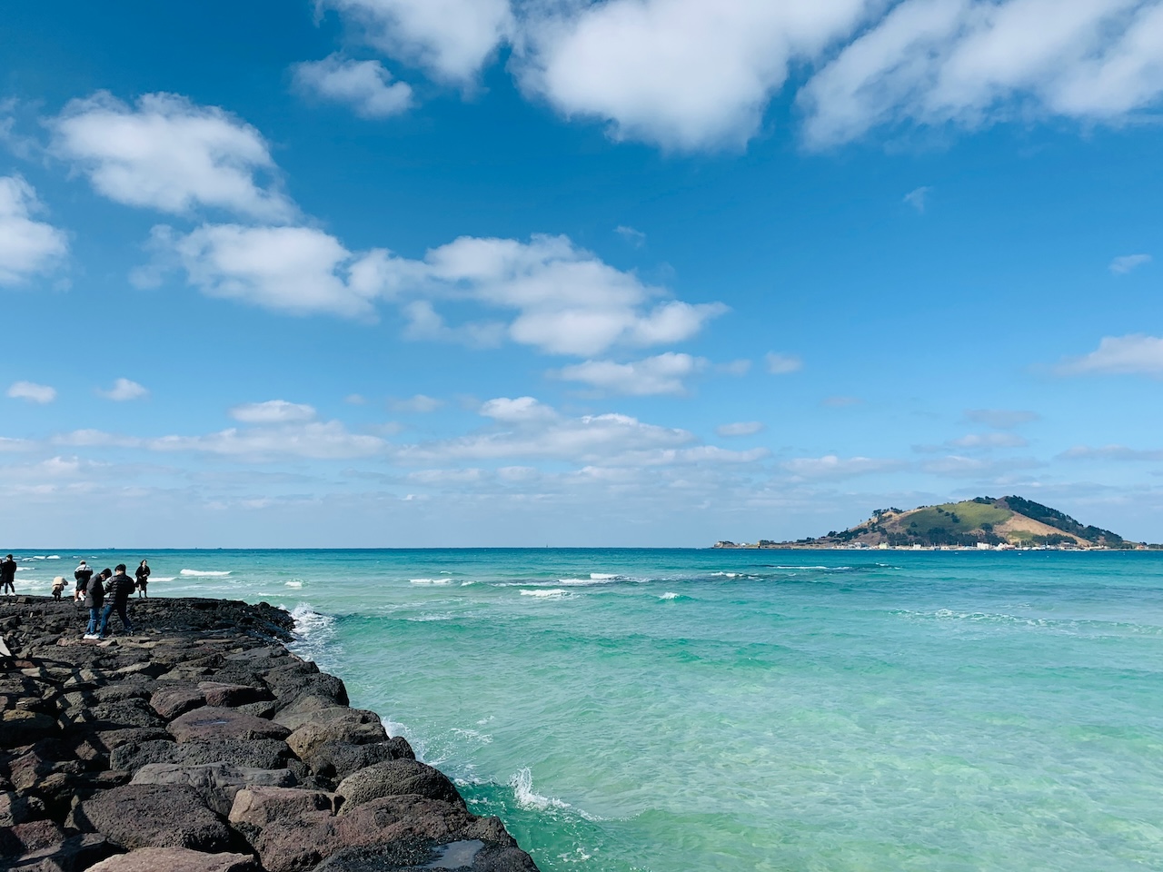 Beautiful Jeju Island coastline with turquoise waters and rocky shores